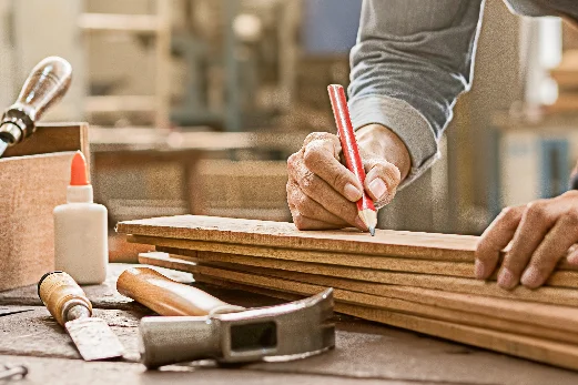 Person zeichnet auf Holzlatten
